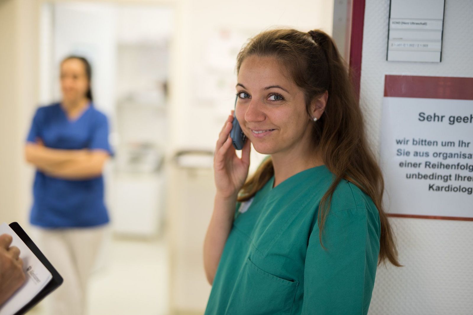 Freundlich lächelnde Krankenschwester im Gespräch am Telefon